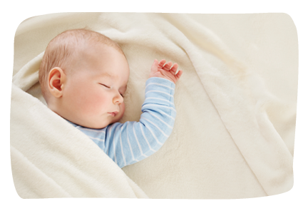 bébé dormant sous un plaid